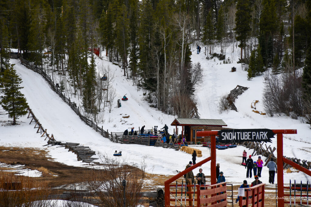 Snow tubing park at Beaver Meadows Resort in Red Feather lakes showing tube lifts and visitors.