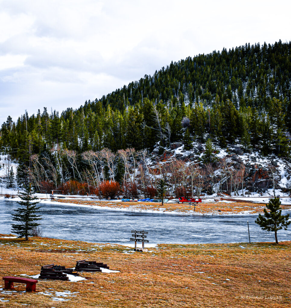 Snowy landscape with icy lake and trees