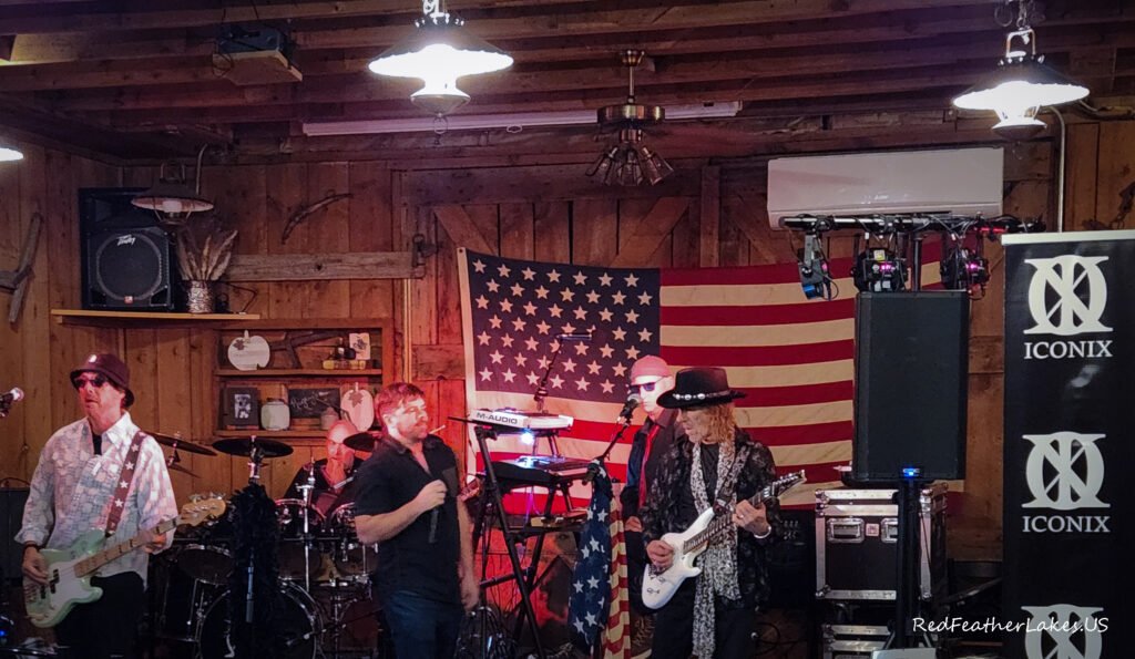 80's Rock Band Iconix performing live on stage with American flag backdrop at Rigby's Roadhouse in Livermore, Colorado