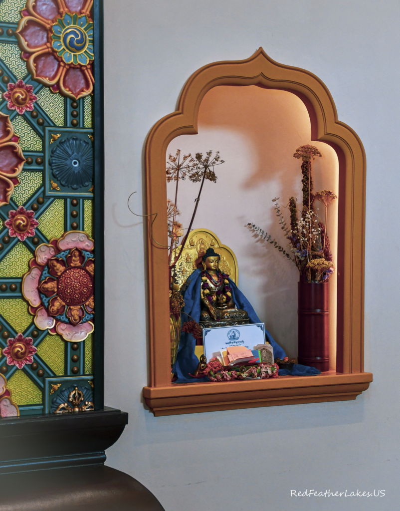 Intricately carved and painted wooden column beside an alcove inside The Great Stupa of Dharmakaya at Drala Mountain Center in Red Feather Lakes, Colorado