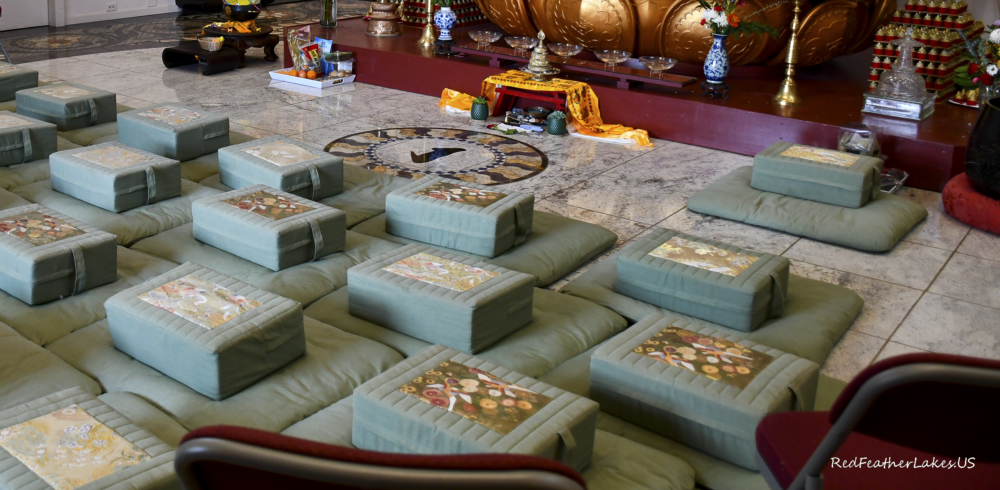 Meditation cushions in serene Buddhist temple setting.