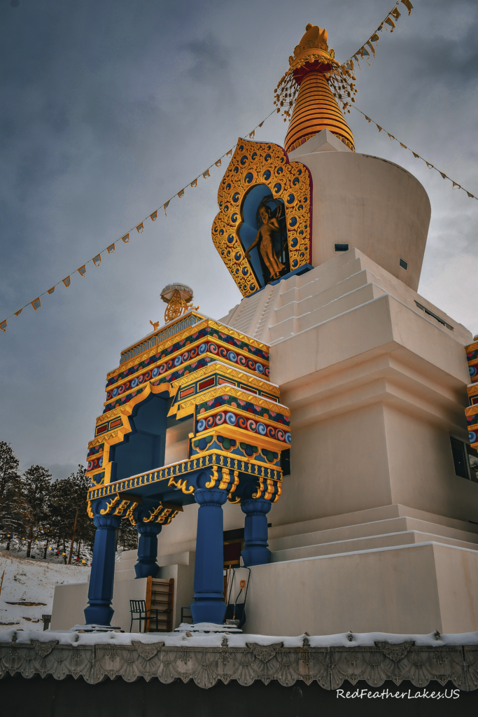 Colorful Buddhist stupa with intricate designs in snow.