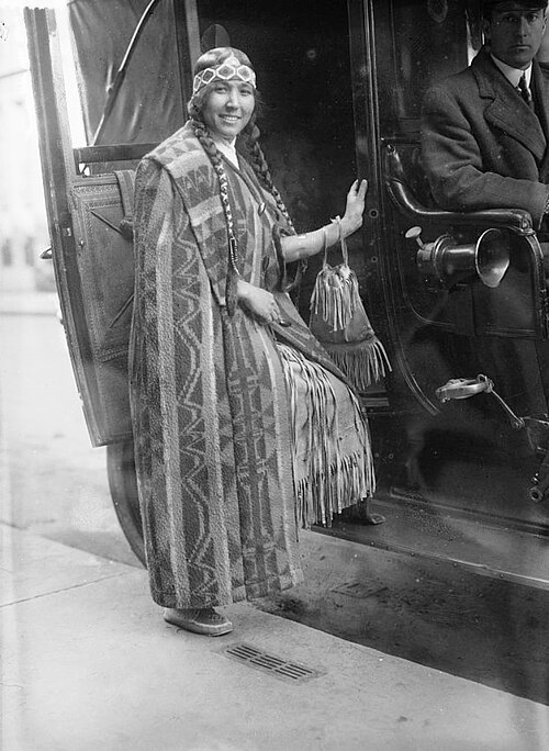Woman in traditional attire exits a car.