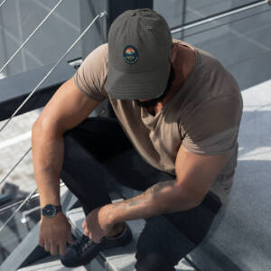 Muscular man sitting on outdoor steps wearing cap