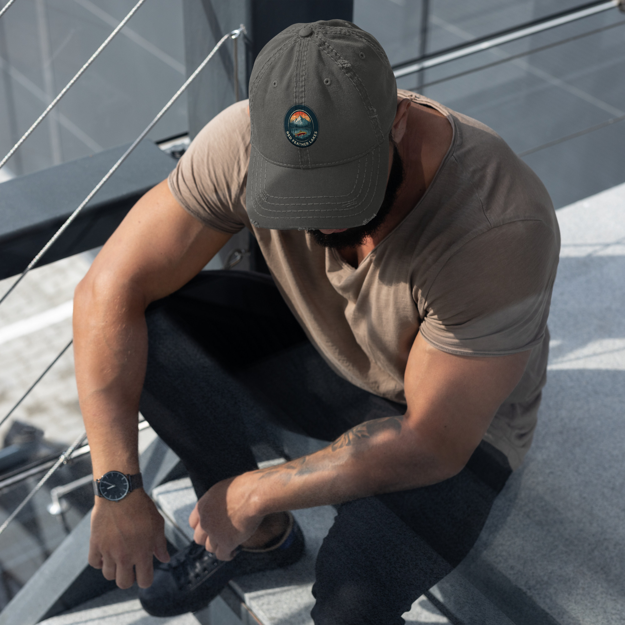 Muscular man sitting on outdoor steps wearing cap
