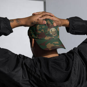 Person wearing camouflage baseball cap with patch