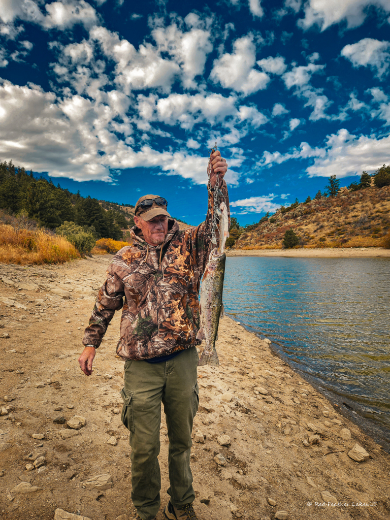 Red Feather Lakes.US-77 Man holding large trout by lakeside