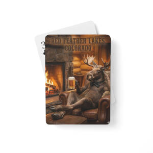 Moose in armchair holding beer by fireplace