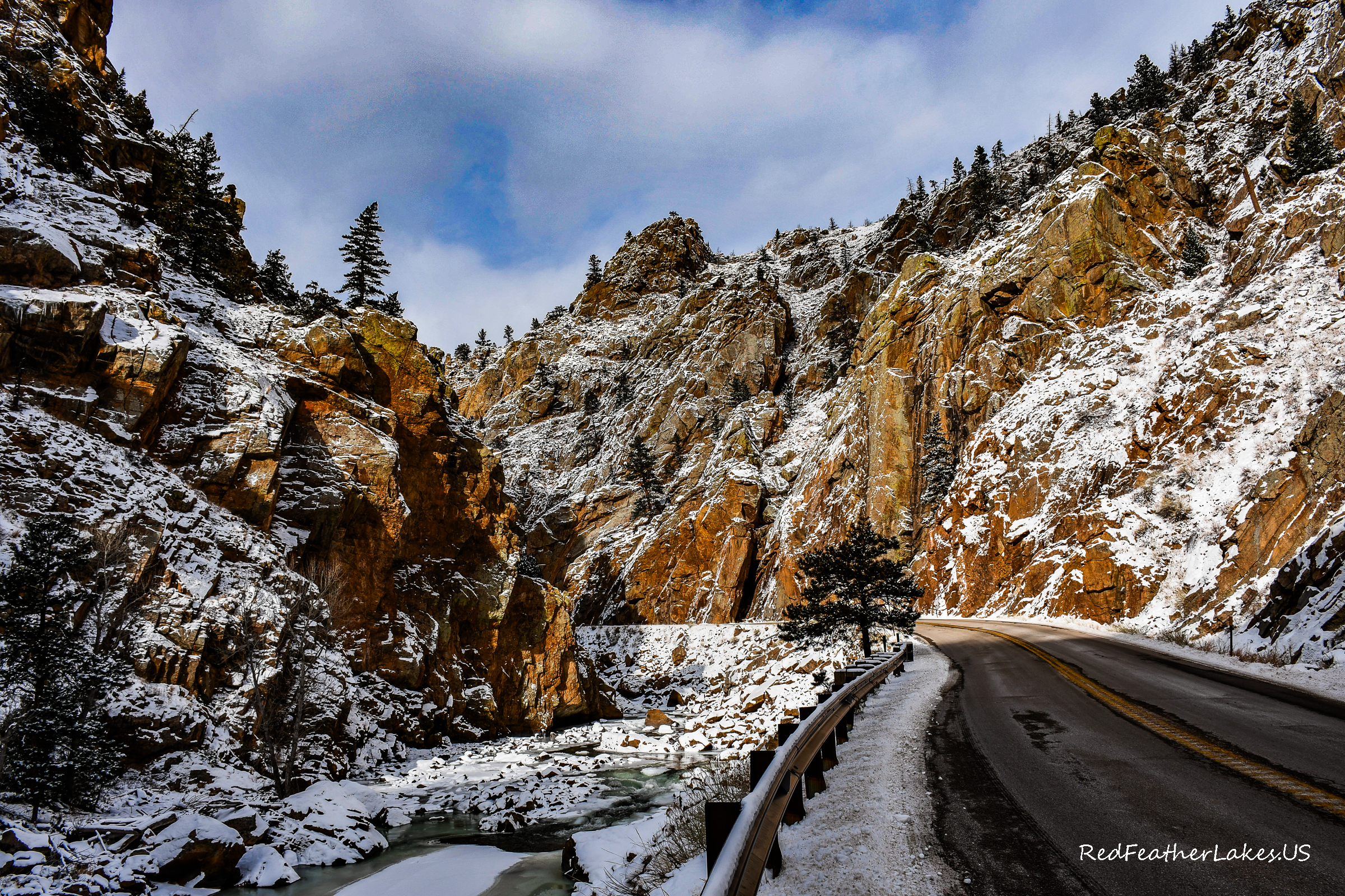 Snow-dusted canyon walls and a curving road along the Cache la Poudre Scenic Byway in winter